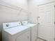 Functional laundry room featuring a side-by-side washer and dryer and wire shelving for optimal storage at 23901 Coral Ridge Ln, Land O Lakes, FL 34639