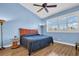 Bright bedroom featuring wood-look flooring, ceiling fan, and plantation shutters at 2537 Gloriosa Dr # 2, Palm Harbor, FL 34684