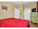 Bedroom with red bedspread, wood flooring, and a functional wardrobe at 2537 Gloriosa Dr # 2, Palm Harbor, FL 34684