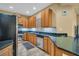 Well-lit kitchen showcasing wood cabinets, granite countertops, stainless steel appliances, and tile flooring at 2537 Gloriosa Dr # 2, Palm Harbor, FL 34684