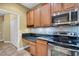 Well-lit kitchen features wooden cabinets, stainless steel appliances, and granite countertops at 2537 Gloriosa Dr # 2, Palm Harbor, FL 34684