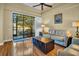 Comfortable living area with hardwood floors, ceiling fan, and sliding glass doors leading to a patio with a lake view at 2537 Gloriosa Dr # 2, Palm Harbor, FL 34684