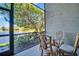Screened-in patio area showcasing a charming wicker dining set with peaceful views of the lake and surrounding foliage at 2537 Gloriosa Dr # 2, Palm Harbor, FL 34684