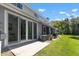 Home's exterior with sliding glass doors, patio, and a green lawn along a canal at 2747 Enterprise E Rd # 17, Clearwater, FL 33759