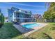 Lush backyard featuring a refreshing pool, a shaded patio with seating, and ample space for outdoor activities at 289 8Th N Ave, Tierra Verde, FL 33715