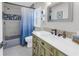 Cozy bathroom featuring a vanity with a white countertop, decorative tiling, and a shower with a blue-ombre curtain at 289 8Th N Ave, Tierra Verde, FL 33715