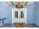 Close-up of the double front door showcasing a welcome mat, hanging turtles and a sea-themed light fixture at 289 8Th N Ave, Tierra Verde, FL 33715