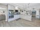 Open kitchen and living area with luxury appliances, gray stone counters and white cabinets at 289 8Th N Ave, Tierra Verde, FL 33715
