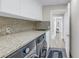 Well-equipped laundry room with a washer, dryer, granite countertops, and ample cabinet space at 289 8Th N Ave, Tierra Verde, FL 33715