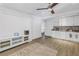 Open-concept living area with a TV console, a kitchenette with white cabinets, and a tile backsplash, creating a seamless space at 289 8Th N Ave, Tierra Verde, FL 33715