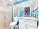 Bathroom with a sliding-glass door on the shower and bright-blue walls at 3500 El Conquistador Pkwy # 242, Bradenton, FL 34210