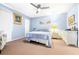 Bedroom with light-blue walls and a fan with beach-themed art and decor at 3500 El Conquistador Pkwy # 242, Bradenton, FL 34210