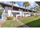 Charming two-story condo building with lush landscaping and mature palm trees at 3500 El Conquistador Pkwy # 242, Bradenton, FL 34210