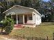 Quaint one-story home featuring a cozy front porch and charming curb appeal, enclosed by a chain-link fence at 3601 N 18Th St, Tampa, FL 33605
