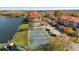 Aerial view of community featuring a tennis court, lake, and apartment buildings with red tile roofs at 4209 Woodstorks Walk Way # 1304, Lutz, FL 33558