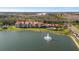 Scenic aerial view of Calusa Trace condos overlooking a pristine lake with a fountain and lush landscaping at 4209 Woodstorks Walk Way # 1304, Lutz, FL 33558