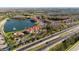 Wide aerial view of the complex by the lake, and the surrounding area including a four-lane highway at 4209 Woodstorks Walk Way # 1304, Lutz, FL 33558