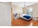 Bright bedroom featuring a large window, ceiling fan, and wood-look laminate floors at 4209 Woodstorks Walk Way # 1304, Lutz, FL 33558