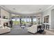 Elegant community lounge featuring floor-to-ceiling windows with views of the pool area, fireplace, and comfortable seating at 4209 Woodstorks Walk Way # 1304, Lutz, FL 33558