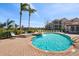 Community pool featuring a hot tub, lounge chairs, and lush landscaping, with lake and building views at 4209 Woodstorks Walk Way # 1304, Lutz, FL 33558