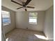 Bright bedroom featuring tile floors, a ceiling fan, and two windows allowing ample natural light at 4501 67Th N St, St Petersburg, FL 33709