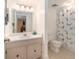 Bright bathroom features a neutral vanity, updated lighting, and a shower with a stylish blue and white curtain at 6311 Newtown Cir # 11B2, Tampa, FL 33615