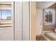 Bright hallway with white closet doors, a window, and a white entry door with carpeted stairs at 6311 Newtown Cir # 11B2, Tampa, FL 33615