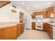 Well-lit kitchen featuring wood cabinets, tile floors, and white appliances at 6311 Newtown Cir # 11B2, Tampa, FL 33615