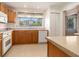 Eat-in kitchen with wood cabinets, tile floors, and modern white appliances at 6311 Newtown Cir # 11B2, Tampa, FL 33615