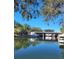 Peaceful waterfront featuring a covered boat lift and a boat slip, all with a clear blue sky overhead at 6311 Newtown Cir # 11B2, Tampa, FL 33615