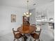 Elegant dining room features a hardwood table, china cabinet, and chandelier lighting at 6837 Northlake Dr, Zephyrhills, FL 33542