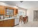 Cozy kitchen featuring wood cabinets, tile backsplash, and dining area with natural light at 6930 Greenbrier Dr, Seminole, FL 33777