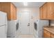 Laundry room with cabinets above the washer and dryer and a door to the outside at 6930 Greenbrier Dr, Seminole, FL 33777