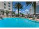 Beautiful pool area featuring clear blue water and a backdrop of swaying palm trees against a blue sky at 700 S Harbour Island Blvd # 204, Tampa, FL 33602