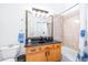 Bathroom boasts wood vanity, granite countertop, framed mirror, and shower-tub combo at 733 Seminole Blvd, Tarpon Springs, FL 34689