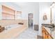 Bright bathroom with a tub next to a window and marble floors at 733 Seminole Blvd, Tarpon Springs, FL 34689