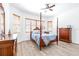 Bright bedroom features a four-poster bed, wood floors, and natural light from the windows at 733 Seminole Blvd, Tarpon Springs, FL 34689