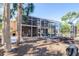 Tan home featuring a screened-in porch with stairs at 733 Seminole Blvd, Tarpon Springs, FL 34689