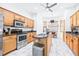 Bright kitchen with stainless steel appliances, wooden cabinets, and center island at 733 Seminole Blvd, Tarpon Springs, FL 34689