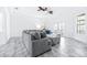 Bright living room featuring gray couch, tile floors, ceiling fan and natural light at 733 Seminole Blvd, Tarpon Springs, FL 34689