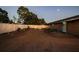 Expansive backyard featuring new soil, lush trees, and a privacy fence at dusk at 7505 Exter Way, Tampa, FL 33615
