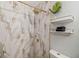 Contemporary shower with gold trim, marble-style tiling, and stylish shelving at 7505 Exter Way, Tampa, FL 33615