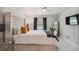 Spacious bedroom with a tufted headboard, large window, and decorative throw blanket at 7505 Exter Way, Tampa, FL 33615