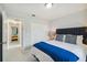 Modern bedroom with a black headboard, white tile floors, and a glimpse of the hallway at 7505 Exter Way, Tampa, FL 33615