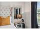 Bedroom features a tufted headboard, mirror, contemporary lamp, and window with blinds at 7505 Exter Way, Tampa, FL 33615