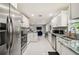 Open kitchen with stainless appliances, white cabinets, granite counters, and an view to the living space at 7505 Exter Way, Tampa, FL 33615