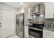Contemporary kitchen featuring stainless steel appliances and gray backsplash at 7505 Exter Way, Tampa, FL 33615