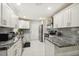 Contemporary kitchen featuring white cabinets, stainless steel appliances, and a stylish backsplash at 7505 Exter Way, Tampa, FL 33615