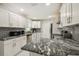 Well-lit kitchen boasts white cabinets, granite countertops, stainless steel appliances, and a stylish backsplash at 7505 Exter Way, Tampa, FL 33615