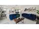 Inviting living room featuring modern decor, plush blue sofas, and bright, open layout to the kitchen and dining area at 7505 Exter Way, Tampa, FL 33615